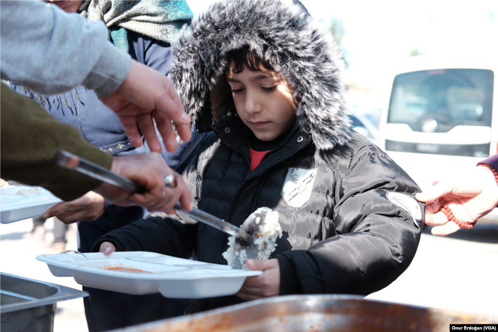 Kampta sıcak yemek, su, süt, battaniye ve bağışla gelen çeşitli kıyafetler dağıtılıyor. 
