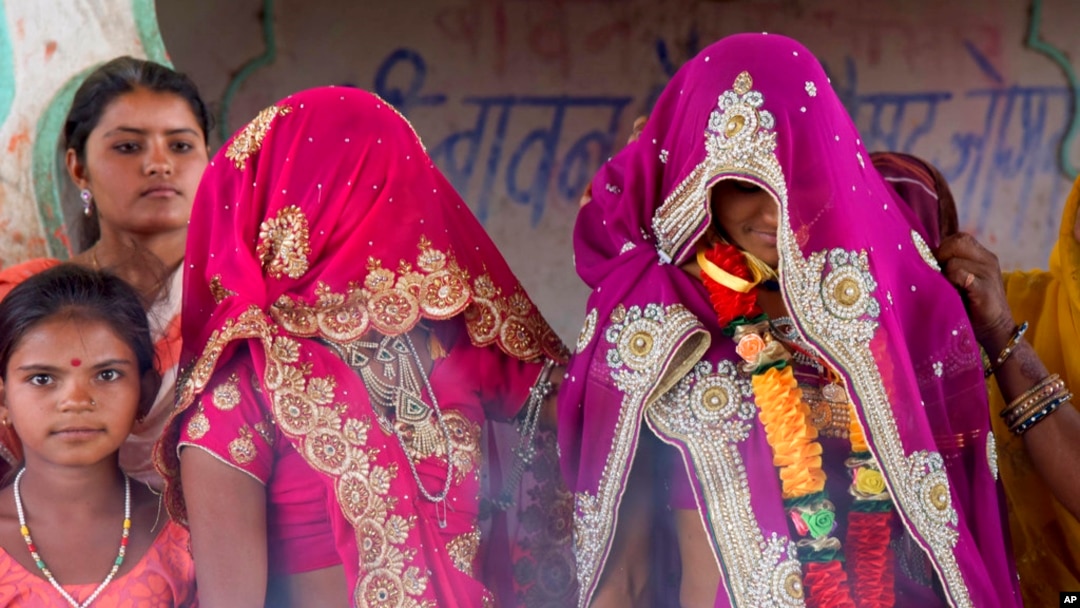 FILE - In this April 17, 2017, photo, an underaged bride, right, stands with family members during her marriage at a Hindu temple near Rajgarh, Madhya Pradesh state, India.