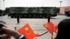 2019年10月1日，北京，紀念中華人民共和國成立70週年的閱兵式上，攜帶DF-41彈道飛彈的軍車駛過，觀眾揮舞著中國國旗。