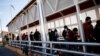 FILE - Migrants expelled from the U.S. and sent back to Mexico under Title 42 walk towards Mexico at the Paso del Norte International border bridge, in Ciudad Juarez, Mexico, April 1, 2022.