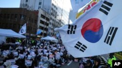 Participants hold signs during a rally calling on the Constitutional Court to dismiss the President Yoon Suk Yeol in Seoul, South Korea, Dec. 15, 2024. The signs read "Immediately arrest." 