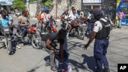 FILE - Police officers man a checkpoint checking for weapons, in the Petion-Ville of Port-au-Prince, Haiti, Nov. 19, 2024.