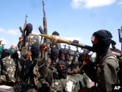 FILE - Armed al-Shabab fighters ride on pickup trucks as they prepare to travel into Mogadishu, Somalia, Dec. 8, 2008.
