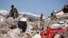 A man sits amid rubble in the aftermath of a deadly earthquake in Kahramanmaras, Turkey February 11, 2023.