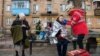 FILE - A paramedic helps a woman injured at the site of a residential district after it was hit by shelling, in Kyiv, Ukraine, March 18, 2022. Doctors in the U.S. are using telemedicine to provide advice to Ukranians hurt in the fighting or attempting to manage chronic diseases. 