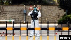 香港爆發新冠病毒期間，一名身穿個人防護裝備的中國解放軍士兵在香港的解放軍總部入口守衛。（2022年3月15日）