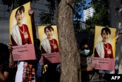 Protesters hold up pictures of detained Myanmar civilian leader Aung San Suu Kyi during a demonstration outside the Embassy of Myanmar in Bangkok on Dec. 19, 2022