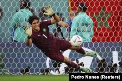 Yassine Bounou dari Maroko beraksi selama adu penalti. (Foto: REUTERS/Pedro Nunes)