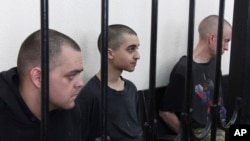 Фото: громадяни  Британії Ейден Еслін та Шон Піннер та громадянин Марокко Брагім Саадун в проросійському суді в Донецьку, 9 червня 2022 року. (AP Photo)
