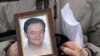 RUSSIA -- A portrait of lawyer Sergei Magnitsky, who died in jail, is held by his mother Nataliya Magnitskaya, as she speaks during an interview with the AP in Moscow, November 30, 2009