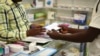 FILE — A man buys a face mask at a pharmacy in Kitwe, Zambia, Feb. 6, 2020. Amid the pandemic, Zambia faced a deadline to clear debt owed to external investors. On Saturday, the IMF announced progress.
