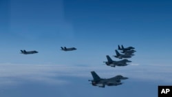 In this photo provided by South Korea Defense Ministry, U.S. and South Korea Air Force fighter jets fly in formation during a joint drill on Tuesday, June, 7, 2022. The South Korean and U.S. militaries flew 20 fighter jets over South Korea's western sea T