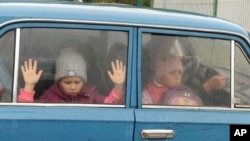 ARHIVA - Deca gledaju kroz prozor automobila dok zajedno sa drugom decom iz regiona Harkova stižu u privremeni smeštaj u prihvatnom kampu u Belgorodu, u Rusiji, 14. septembra 2022. Hiljade dece pobeglo je iz severoistočne Ukrajine u Rusiju tokom kontraofanzive ukrajinskih snaga.