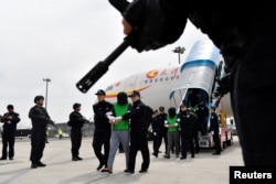 中國警察在天津機場押送一批從菲律賓遣返的台灣籍電信詐騙嫌疑人。 （2018年4月4日）