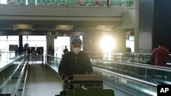 A passengers walks along a bridge in Hong Kong international airport in Hong Kong, Sept. 23, 2022. 