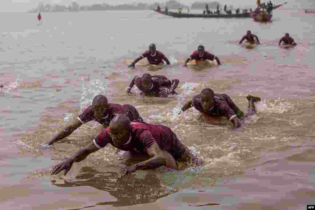 Participants use round gourds to navigate during the annual boat regatta in Yauri, Kebbi State, Nigeria, Feb. 15, 2025. The regatta festival started about 200 years ago as a display of naval strength of the Gungu people, where the Gungu warriors annually attacked dangerous hippopotamus that were destroying farmlands. 