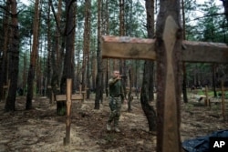 ARHIVA - Oleg Kotenko, komesar za pitanja nestalih osoba, snima kamerom na telefonu neidentifikovane grobove civila i ukrajinskih vojnika u Izijumu, 15. septembra 2022.