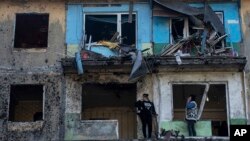 Žene stoje na balkonima svojih stanova uništenih u ruskom bombardovanju Dobropilja, u regionu Donjecka, istočna Ukrajina, 30. aprila 2022.
