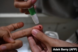 Seorang wanita memeriksakan kadar gula darahnya di laboratorium di Jakarta. (Foto: AFP/Adek Berry)