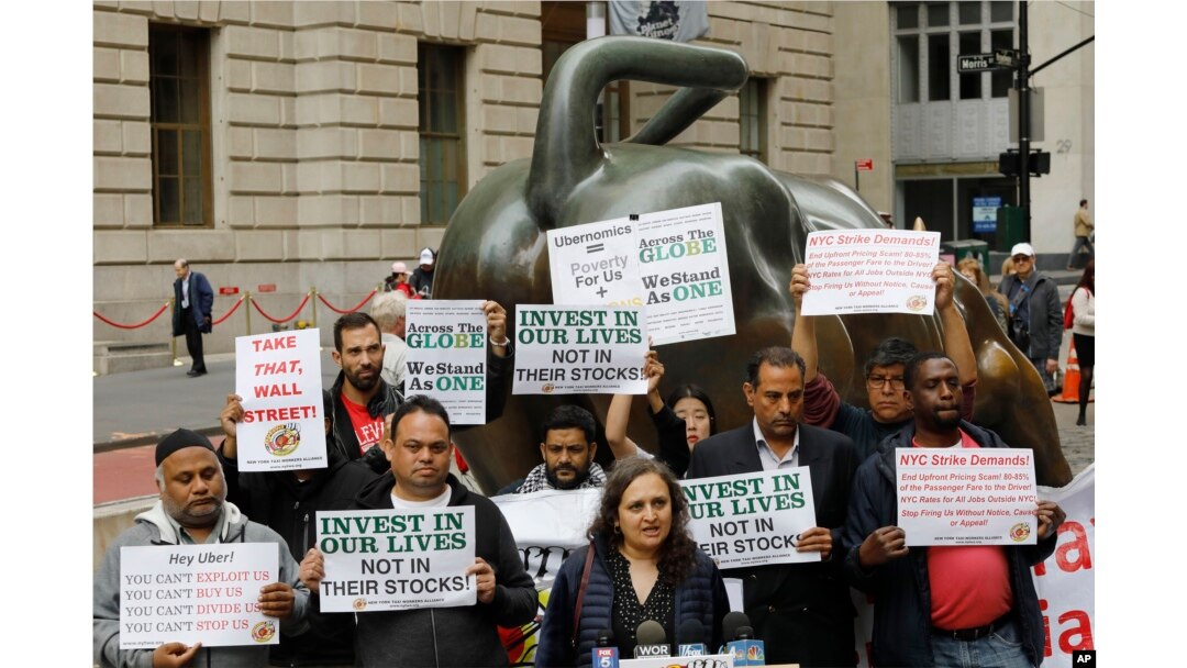Uber drivers protest next to the Charging Bull statue in New York's financial district, May 8, 2019. The protests arrive just ahead of Uber's initial public stock offering, which is planned for May 10, 2119.