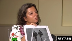 RT Editor-in-Chief Margarita Simonyan shows an image of the two Skripal poisoning suspects during an interview with Aleksandr Petrov and Ruslan Boshirov, who are suspected by the British authorities of poisoning former GRU officer Sergei Skripal and his daughter Yulia.