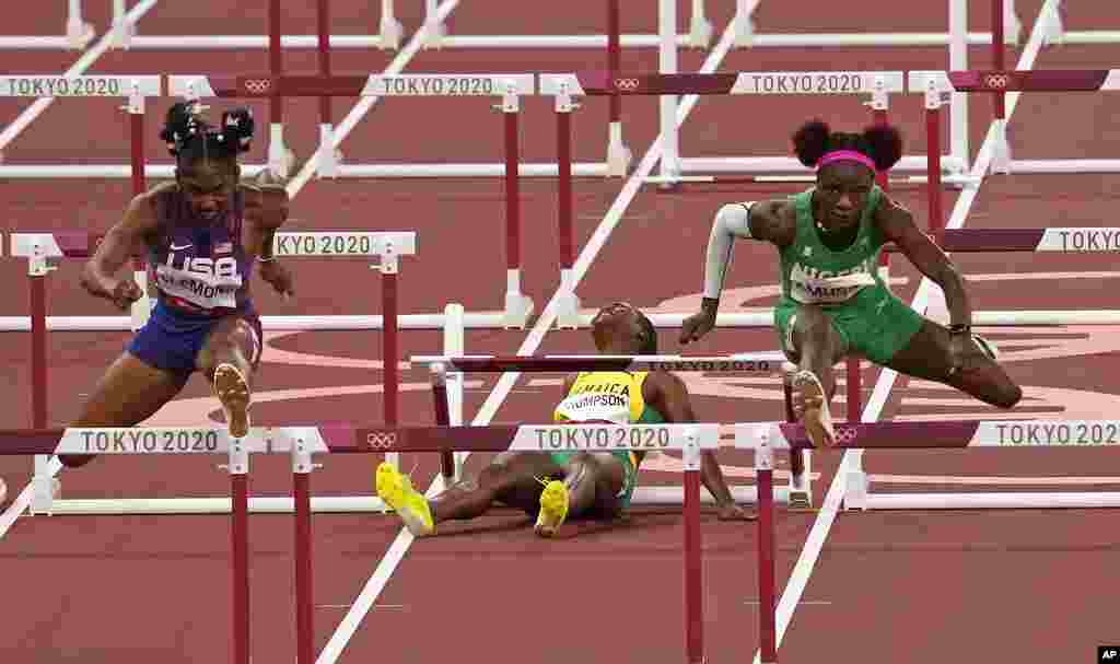 Yanique Thompson, of Jamaica, center, reacts as she pulls up during a women's 100-meter hurdles semifinal at the 2020 Summer Olympics, Sunday, Aug. 1, 2021, in Tokyo, Japan. At left is Christina Clemons, of United States, and at right, Tobi Amusan, of Nigeria. (AP Photo/Charlie Riedel)