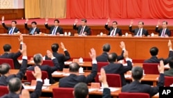 2021年11月11日，中共第19屆中央委員會第六次全體會議上，政治局常委們舉手表決。從左向右依次是韓正、王滬寧、栗戰書、習近平、李克強、汪洋和趙樂際。（照片由新華社發表，美聯社提供。）