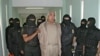 (FILES) This handout picture released by the Mexican Federal Preventive Police (PFP) shows members of the Federal Preventive Police guarding drug trafficker Rafael Caro Quintero (C) after an operation at the Puente Grande prison in Guadalajara, Jalisco, 4
