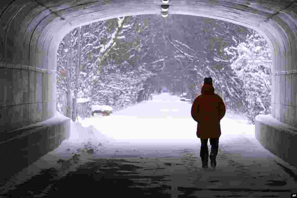 Uma pessoa caminha por um túnel ao longo do trilho Monon, coberto de neve, em Carmel, Indiana, a 6 de janeiro de 2025.