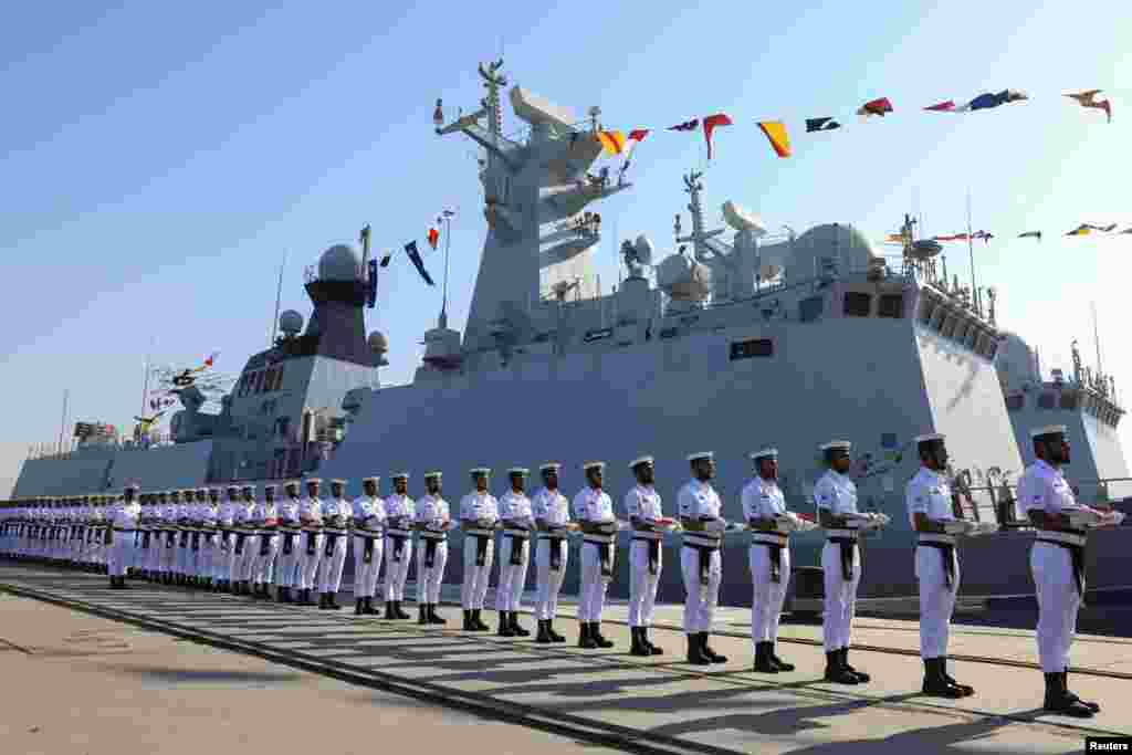 Pakistan Navy's servicemen stand as they carry national flags of participating countries during the opening ceremony of Pakistan Navy's 9th Multinational Maritime Exercise AMAN-25, under the slogan "Together for Peace," in Karachi, Pakistan.