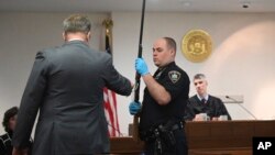 Tužilac pokazuje na pušku kojojm je Monahan ubio Kejtlin Gilis na ročištu 23. januara 2024. (Will Waldron/The Albany Times Union via AP)