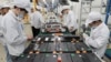 FILE - Workers at a factory for Xinwangda Electric Vehicle Battery Co. Ltd, which makes lithium batteries for electric cars and other uses, in Nanjing in China's eastern Jiangsu province, March 12, 2021.