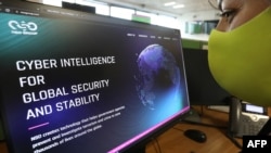 Seorang perempuan memeriksa situs web spyware Pegasus buatan Israel di sebuah kantor di ibu kota Siprus, Nicosia, 21 Juli 2021. (Foto: AFP)