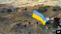 Ukrajinski vojnici dižu zastavnu na Zmijskom ostrvu, u Crnom moru (Foto: AP/Ukrainian Defence Ministry Press Office)