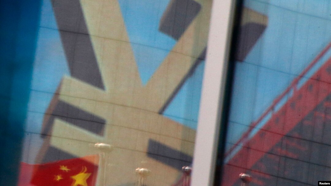 FILE - China's national flag is reflected on an advertisement of a commercial bank bearing the sign of the Chinese yuan at a branch of a commercial bank at a business district in Beijing, China, Jan. 21, 2016.