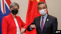 在印尼度假勝地巴厘島努沙杜瓦舉行的二十國集團外長會議期間，澳大利亞外交部長黃英賢(左)與中國外交部長王毅碰肘互致問候。（2022年7月8日）
