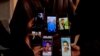 People display the photos of their relatives on mobile phones as they join members of the Syrian civil defense group, known as the White Helmets, in search of prisoners at the Sednaya prison, in Sednaya, Dec. 11, 2024. 