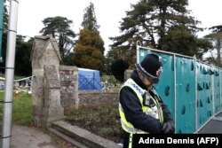 U.K. -- A policeman stands guard at temporary fencing at the London Road Cemetery where the wife and son of former Russian spy Sergei Skripal are buried, in Salisbury, March 14, 2018