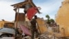 A Somali soldier stands amid ruins in Mogadishu, May, 9, 2016, after a suicide car bomber linked to al-Shabab struck traffic police headquarters. Somali and U.S. special forces led a joint raid Tuesday on a terrorist base.