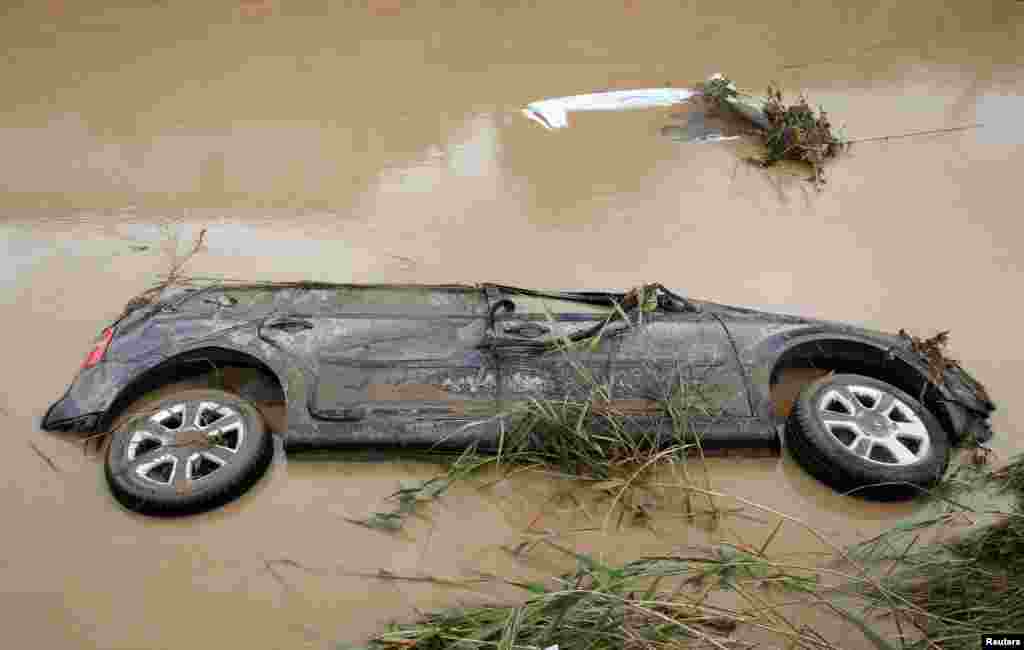A car is seen submerged following floods in Livorno, Italy.