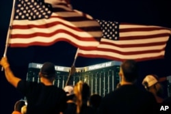 People form a human chain around the shuttered site of a country music festival where a gunman opened fire on the first anniversary of the mass shooting in Las Vegas, Oct. 1, 2018.
