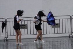 People walk in the rainstorm as Typhoon Lekima approaches Shanghai, China, Aug. 10, 2019.