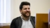 A leading associate of Russian opposition leader Alexei Navalny, Leonid Volkov, smiles in a courtroom during a hearing in Moscow, March 31, 2017.