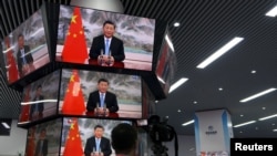 上海舉行的中國國際進出口展銷會媒體中心的多面電視螢幕正在播放中國領導人習近平的演講。 （2021年11月4日）
