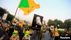 FILE - Kataib Hezbollah Iraqi militia gather ahead of the funeral of the Iraqi militia commander Abu Mahdi al-Muhandis, who was killed in an air strike at Baghdad airport, in Baghdad, Jan. 4, 2020.