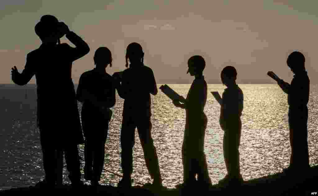 Ultra-Orthodox Jewish boys pray along the Mediterranean Sea in the Israeli city of Herzliya, near Tel Aviv, while performing the "Tashlich" ritual during which "sins are cast into the water to the fish."