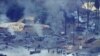 FILE - Smoke rises from an illegal oil refinery in Ogoniland, outside Port Harcourt, Nigeria's Delta region, March 24, 2011. Nigeria is stepping up its efforts to curb crude oil theft, saying it has shut down some illegal refineries.