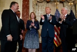 Predsednik Donald Tramp aplaudira državnom sekretaru Majku Pompeu tokom ceremonije polaganja zakletve u Stejt dipartmentu, 2. maja 2018. u Vašingtonu. S leva na desno: Pomeo, njegov sin Nikolas Pompeo, njegova supruga Suzan pompeo, Tramp i potpeddsednik SAD Majk Pens.