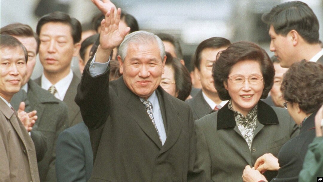 FILE - Former South Korean President Roh Tae-woo, with his wife, Kim Ok-sook, standing beside him, waves to supporters and neighbors after he was released from the Seoul prison in a special amnesty, Dec. 22, 1997.