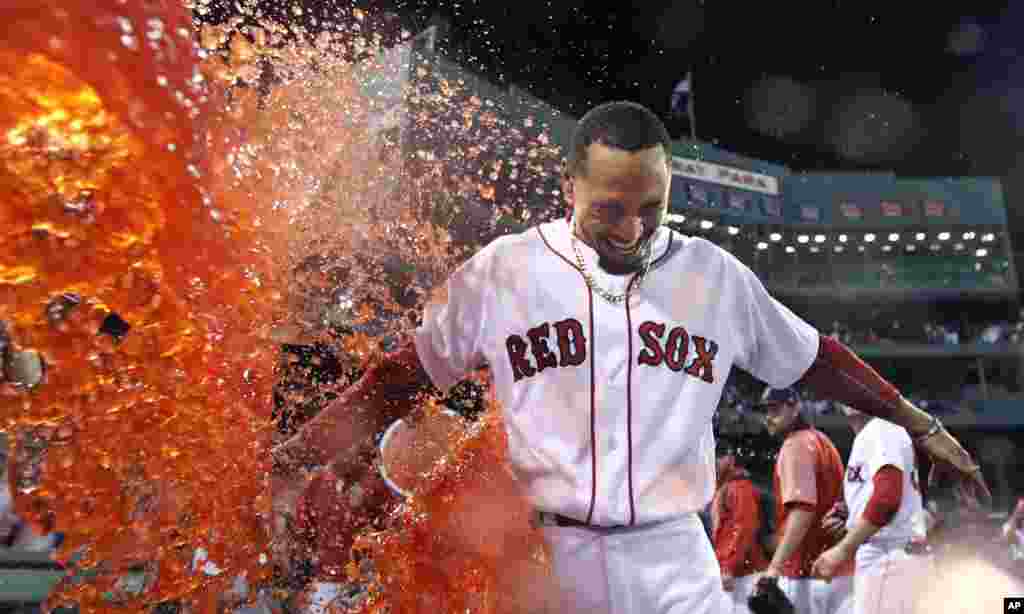 Boston Red Sox's Mookie Betts is doused after his walk-off two-run double during the ninth inning of a baseball game against the St. Louis Cardinals in Boston.